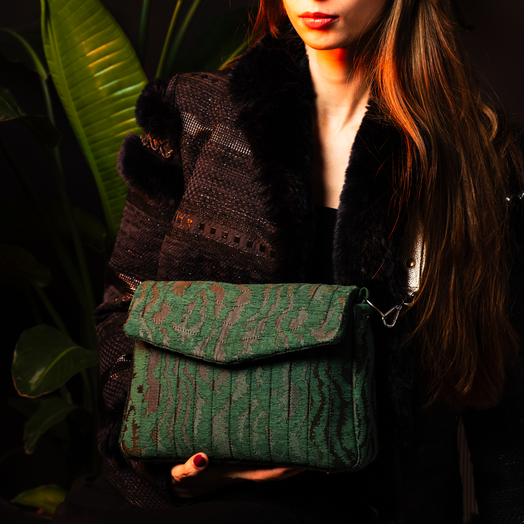 Model wearing the Jade Melon crossbody bag in green moiré jacquard with a silver leather strap, styled for a chic look.