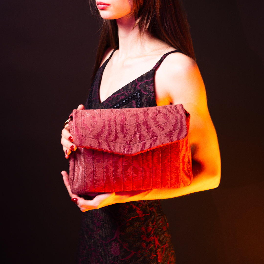 Model wearing the Ballet Blush crossbody bag in pink moiré jacquard, styled for a feminine look.