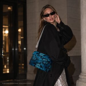 Model wearing the Gemstone Garden blue floral jacquard crossbody bag with a silver leather strap and black outfit.